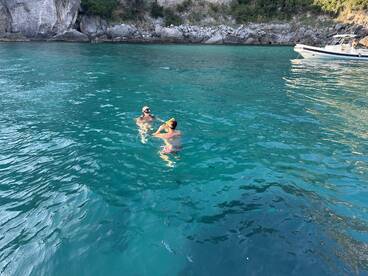 A couple enjoys snorkeling in crystal-clear waters, surrounded by stunning rock formations — a perfect moment for adventure seekers.
