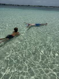 A child and an adult enjoy a refreshing swim in crystal-clear waters, showcasing the perfect setting for a fun day of snorkeling and relaxation.