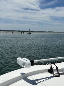 A scenic view of a boat near a sandbar with people enjoying the shallow waters, perfect for a day of relaxation and fun on the water.