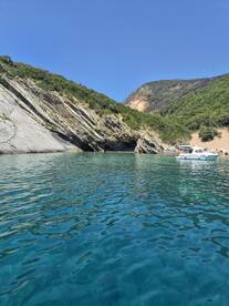 A picturesque view of a serene coastline with a boat anchored nearby, showcasing the beauty of nature and perfect for a relaxing day on the water.