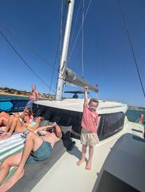 A joyful child celebrates aboard a yacht with family and friends, capturing the essence of fun and relaxation on the water.