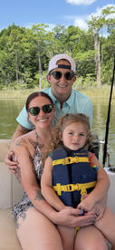 A joyful family enjoys a day on the boat, with a child safely wearing a life jacket — perfect for summer adventures on the water.