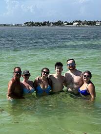 A cheerful group enjoys a refreshing swim in the clear waters, perfect for family outings or beach adventures.