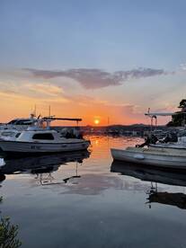 A serene sunset view over a marina with boats gently bobbing in the water, creating a picturesque scene perfect for evening relaxation.