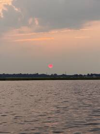 A serene sunset over calm waters, capturing the tranquil beauty of nature — perfect for peaceful evening boat rides.