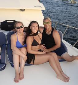A cheerful group of friends enjoys their time aboard a boat, capturing a perfect moment of fun and relaxation on the water.