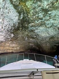 A view from the bow of a boat approaching a stunning cave entrance, showcasing the beautiful rock formations and clear waters — perfect for exploring hidden gems on the water.