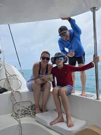 A joyful family enjoys their time aboard a boat, sharing drinks and smiles under the sun — perfect for memorable family outings on the water.