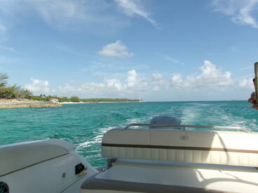 A scenic view from a boat cruising through turquoise waters, showcasing the beautiful coastline and inviting atmosphere of a tropical getaway.