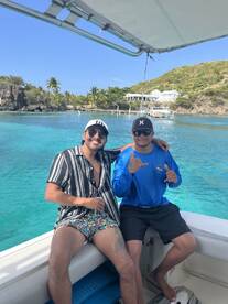 Two friends enjoy a sunny day on a boat, showcasing the perfect atmosphere for fun and relaxation in beautiful waters.