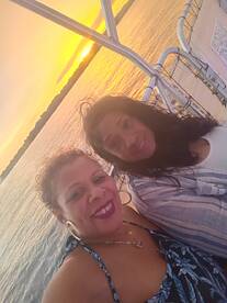 Two friends enjoy a beautiful sunset on the water, capturing a perfect moment of relaxation and celebration aboard a boat.
