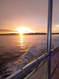 A stunning sunset view from the deck of a boat, showcasing the tranquil waters and vibrant colors of the evening sky — perfect for romantic cruises or peaceful getaways.