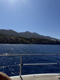 A stunning view of the coastline from a boat, showcasing the sparkling blue waters and mountainous landscape — perfect for capturing the beauty of a day on the water.