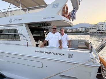 A friendly crew poses on their yacht, inviting guests to book a cruise — perfect for exploring beautiful destinations at sunset.