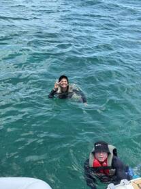 Two individuals enjoy a refreshing swim in clear waters, showcasing the fun and excitement of on-water activities.