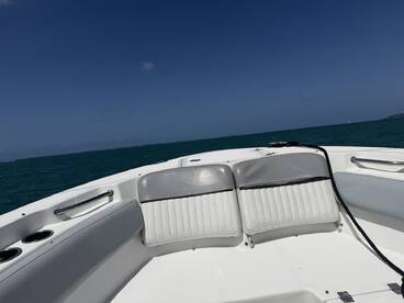 Interior view of a boat's seating area, showcasing comfortable helm seating against a backdrop of turquoise waters — perfect for relaxing while cruising.