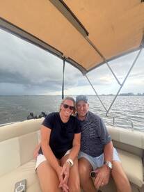 A happy couple enjoys a moment together on a boat, showcasing the perfect setting for a romantic getaway or fun day on the water.