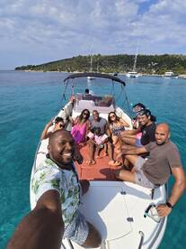 A joyful group enjoys a day on the water, with some ready for snorkeling, showcasing the fun and camaraderie of a boat trip.