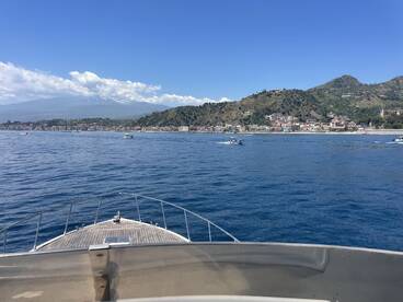 A stunning view from the bow of a boat, showcasing the picturesque coastline and mountains in the background — perfect for exploring scenic destinations.