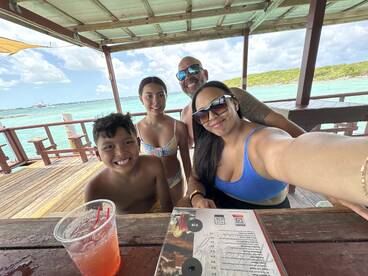 A joyful family enjoys drinks together at a beachside location, capturing a memorable moment in paradise.