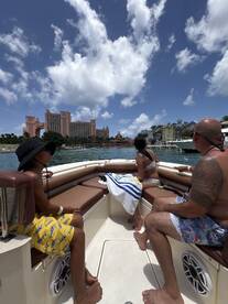 A family enjoys a scenic boat ride with the iconic Atlantis resort in the background, capturing the essence of a fun-filled vacation on the water.