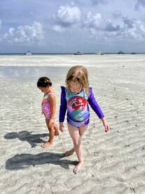 Two children explore the sandy beach, enjoying a fun day in the sun — a perfect family outing by the water.
