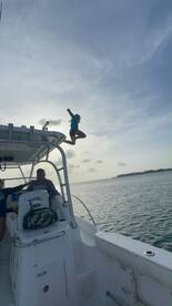 A child joyfully leaps from the boat into the water, capturing the excitement of a fun day on the water.