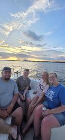A joyful family enjoys a sunset cruise on a boat, capturing a perfect moment of togetherness and celebration on the water.