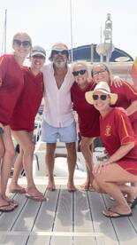 A cheerful group of friends poses together on the deck of a boat, capturing a memorable moment of celebration and camaraderie on the water.