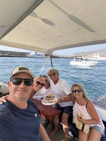A joyful group celebrates a 25th birthday aboard a boat, complete with a delicious cake and smiles all around — perfect for memorable gatherings on the water.