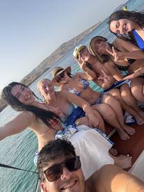 A fun group of friends enjoys a sunny day on the boat, capturing memories with smiles and playful poses — perfect for summer adventures on the water.