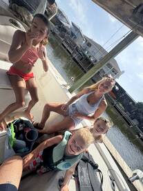 A joyful group of children and an adult enjoy their time on a boat, capturing the essence of family fun on the water.