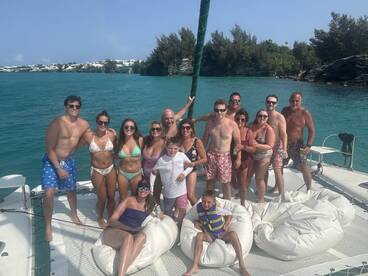 A lively group enjoys a fun day on a catamaran, celebrating together in the sun — perfect for family gatherings or group outings on the water.
