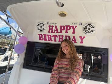 A joyful birthday celebration aboard a boat, featuring festive decorations and a smiling guest, perfect for memorable parties on the water.
