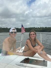 A cheerful couple enjoys a sunny day on the boat, showcasing the perfect summer vibe on the water.