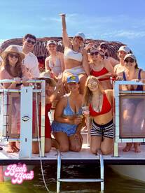 A lively group of friends celebrates on a boat, perfect for bachelorette parties or summer gatherings, enjoying drinks and sunshine.