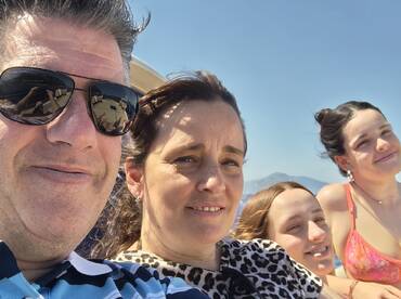 A joyful family captures a selfie on a sunny day aboard a boat, showcasing their fun-filled outing on the water.