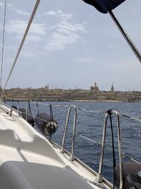 A scenic view from a sailboat showcasing the coastline and architecture of a coastal city, perfect for those exploring by sea.