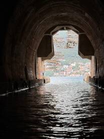 An intriguing view through a tunnel leading to water, showcasing the surrounding landscape. The image captures a unique perspective but lacks clarity.