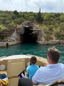 A family enjoys an adventurous boat ride approaching an intriguing tunnel, surrounded by lush greenery — perfect for exploration and memorable experiences on the water.