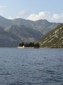 A picturesque view of a secluded island surrounded by mountains, showcasing the stunning natural beauty of the coastline.