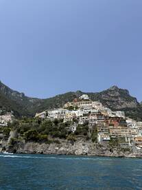 A stunning view of the picturesque coastal town of Positano, showcasing its colorful buildings perched on the cliffs, perfect for travelers seeking scenic beauty along the Amalfi Coast.