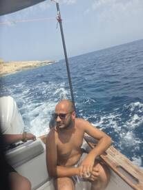 A man relaxes on the deck of a boat, enjoying the scenic views of the ocean — a perfect moment for leisure on the water.