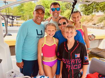 A joyful family poses together on a boat, showcasing their excitement for a day of fun on the water. Perfect for capturing memorable moments during family outings.