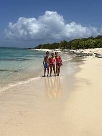 Three children enjoy a sunny day at the beach, creating lasting memories by the turquoise waters — a perfect spot for family fun and adventure.