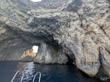 A stunning view of a natural cave formation along the coastline, showcasing the beauty of the surrounding waters — perfect for eco tours and scenic boat trips.