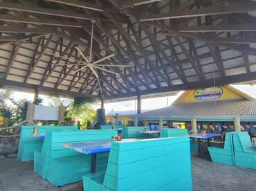 A vibrant interior view of a boat-themed dining area featuring turquoise seating and a spacious layout, perfect for enjoying meals in a relaxed atmosphere.