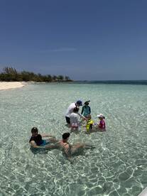A joyful family enjoys a fun day at the beach, playing in the shallow waters and creating lasting memories together.