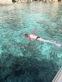 A child enjoys snorkeling in crystal-clear waters, showcasing the beauty of underwater exploration in a tropical paradise.