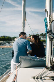 A couple shares a romantic moment aboard a yacht, enjoying the serene views and each other's company — perfect for intimate sailing experiences.